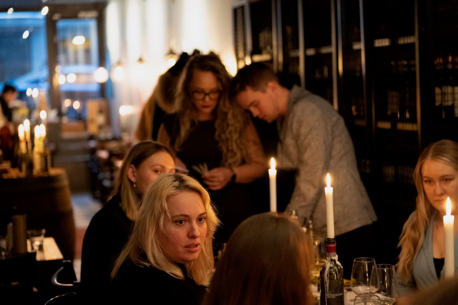 Guests deep in conversation at a candlelit table at a perfume evening